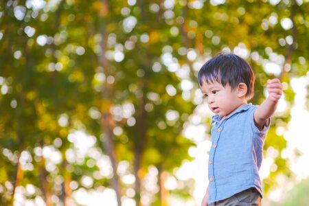Portrait of adorable little boy playing in city park blurred bokeh background Boy in nature