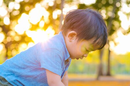 Portrait of adorable little boy playing in city park blurred bokeh background Boy in nature