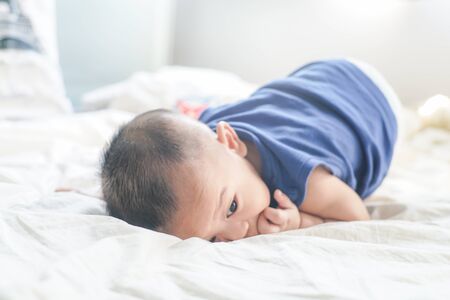 Adorable 6 month baby boy lying  on white blanket sleeping boy healthy concept