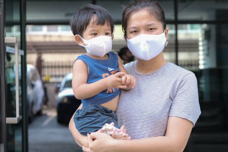 Single mom with kids boy in face mask outdoor city. Mother and child wear facemask during coronavirus and flu outbreak. Virus and illness protectionの写真素材