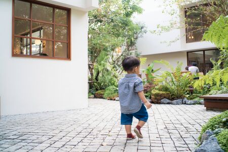 Adorable baby boy toddler walking in garden hpme green tree boy in natureの写真素材