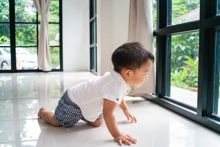Little asian boy crawling on floor in cozy home family concept
