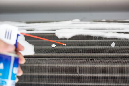 Technician man hand cleaning air condition filter with chemical foam against PM 2.5 duskの写真素材
