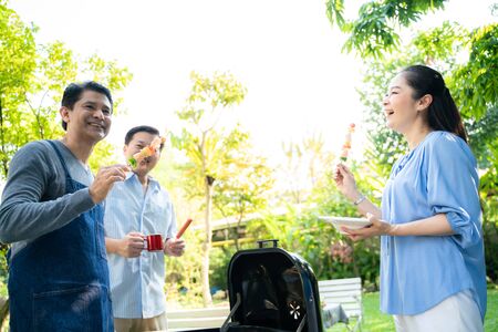 Happy seniors food meeting BBQ grilled party style in the gardenの写真素材