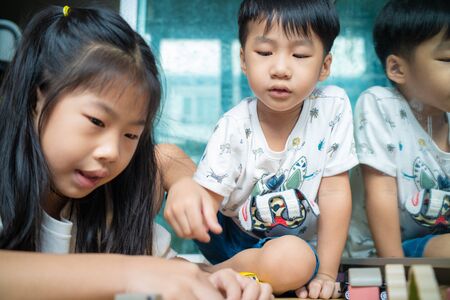 Curious baby boy and girl group studying with toy in modern room little boy and girl educationの写真素材