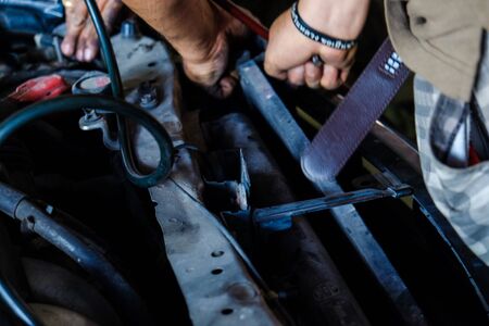 Car servicing man hand replacing of tube cool air, Mechanic repairing a car