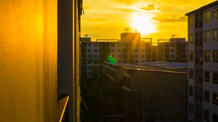 Silhouette condominium building sunset yellow sky with cloud metropolitan cityの写真素材