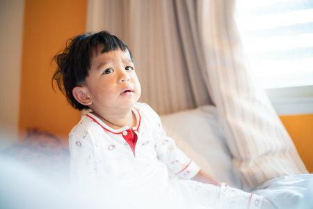 Cute toddler baby boy waking up stretching crying is upset looking awayの写真素材