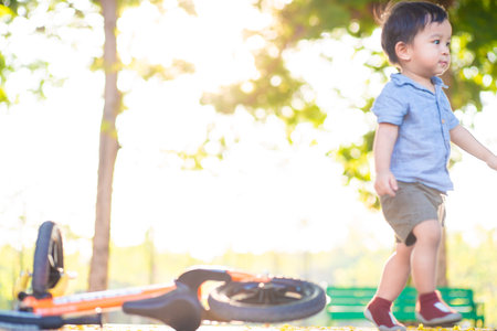 Little asian boy playing balance bike in city park sunset light boy exerciseの写真素材