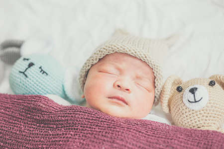 Adorable baby boy sleeping with many cute doll top viewの写真素材