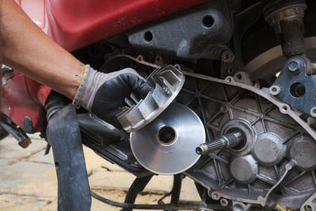 Mechanic man hand fix CVT scooter motorbike at home, Maintenance of motor cycle