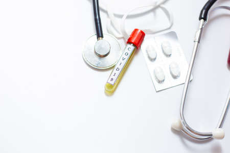 Microbiologist with a tube of biological blood sample contaminated by Coronavirus with label Covid-19 on white backgroundの写真素材
