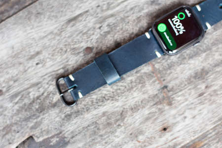 Navy blue leather watch strap with digital watch on wood