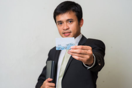 Smart business asian men holding credit card on white backgroundの写真素材