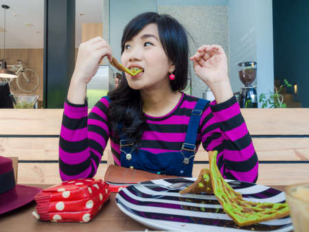 Beautiful asian women sitting in cafe restaurant with food and drinkの写真素材