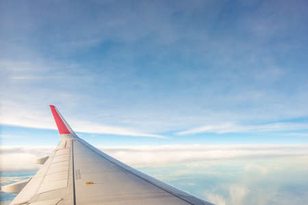 Sky and cloud as seen through airplane window on the wing on sunset time