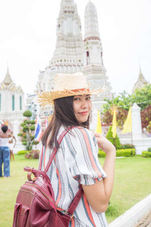 Asian girl tourist smiling while visiting Wat Arun or Temple of Dawn backpacker women, one day tourの写真素材