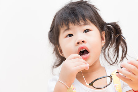 Joyful asian girl with circular glasses on white background, Lovely chileの写真素材