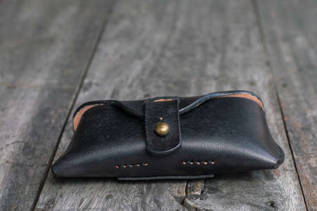 Genuine black cow leather glasses case on wood handmade crafts workingの写真素材