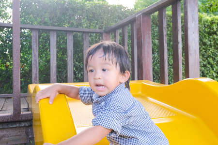 2 year little boy playing slider in park green grass outdoor activityの写真素材