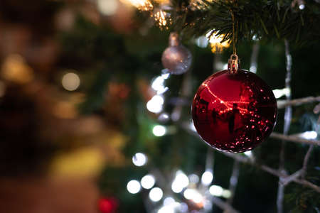 Close up of vintage toned red balls on christmas tree bokeh garlands in the background. New Year concept.の写真素材