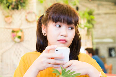 Portrait of asian women use samrtphone sitting in vintage cafe Beautiful womenの写真素材