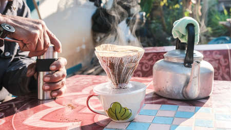 Coffee drip and smoke  with group of people friend hand grind coffee in morning lightの写真素材