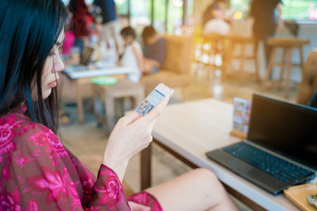 Beautiful asian women texting message on smartphone sitting in coffee shop Business communication conceptの写真素材