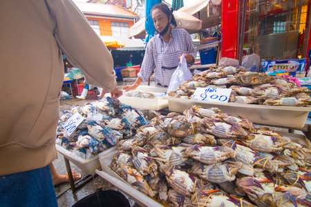 Mahachai Samutsakhon, Thailand - November 7, 2020 : Unidentified people wear surgical mask and choosing seafood fish at Mahachai fresh marketのeditorial素材
