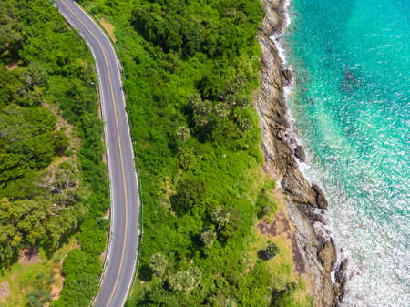 Curve asphalt road on mountain sea island with tree forest aerial view