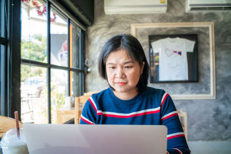 Business freelance women working with laptop sitting in restaurant business technologyの写真素材