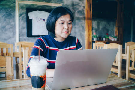 Business freelance women working with laptop sitting in restaurant business technology