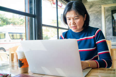 Business freelance women working with laptop sitting in restaurant business technologyの写真素材