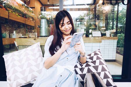 Business asian women use smartphone sitting in cafe coffee timeの写真素材