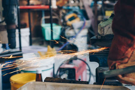 Mechanical man hand use electric grinder with flame sparks on metal business industryの写真素材
