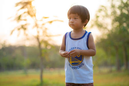 Happy facial face boy playing in tree park sunset light Boy in natureの写真素材
