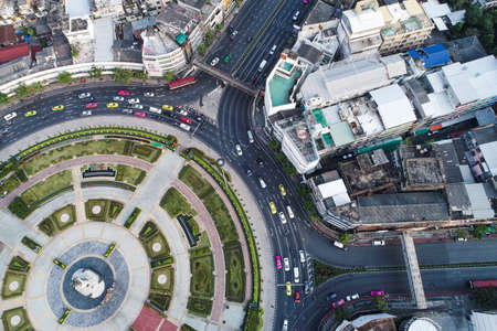 Aerial view vehicle on circular junction road with city building transport industryのeditorial素材