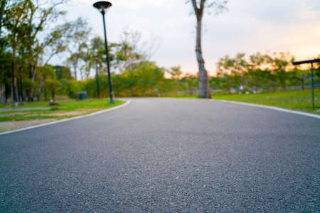 Empty asphalt pathway road in city park sunset running pathの写真素材