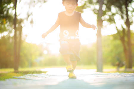 Adorable little boy walking in city park sunset light boy in natureの写真素材