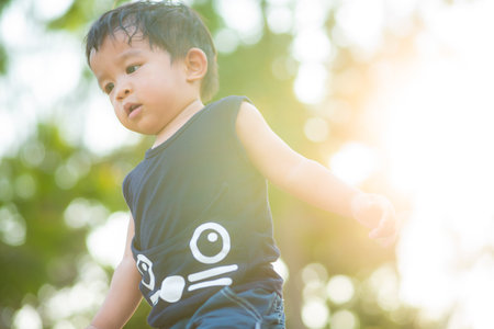 Adorable little boy walking in city park sunset light boy in natureの写真素材