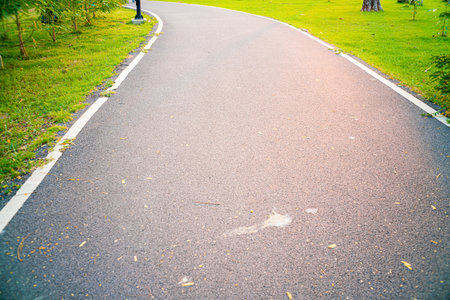 Empty asphalt pathway road in city park sunset running pathの写真素材