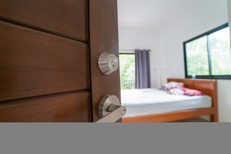 Teak brown wooden door in modern white room looking to insideの写真素材