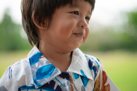 Adorable little asian boy smiling while playing outdoor park sunset light Happy boy