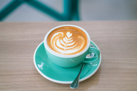 Hot latte art coffe in green cup on wood table aroma drinkの写真素材