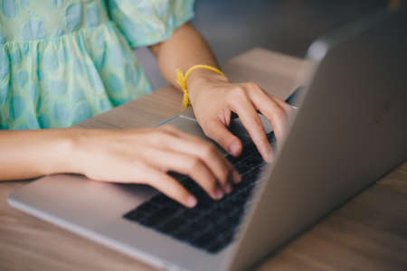 Women hand typing on laptop sitting in office business technologyの写真素材