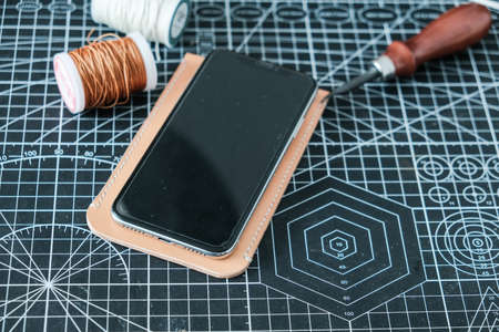 Vegetable tanned leather phone case craftmaship working with thread and tool handmade object