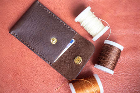 Handmade brown leather card holder craft working on leather background