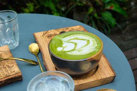 Hot latte art matcha coffee in garden coffee shop drink with nature aromaの写真素材