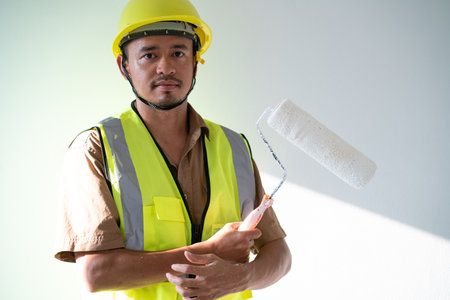 Men paint indoor color with roller paint on white backgroundの写真素材