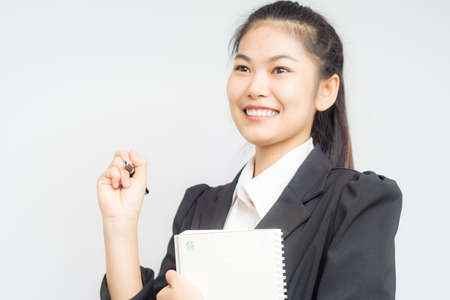 Attractive business asian women gesture hand with pen and book on white backgroundの写真素材
